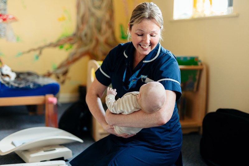 A picture of a nurse holding a baby