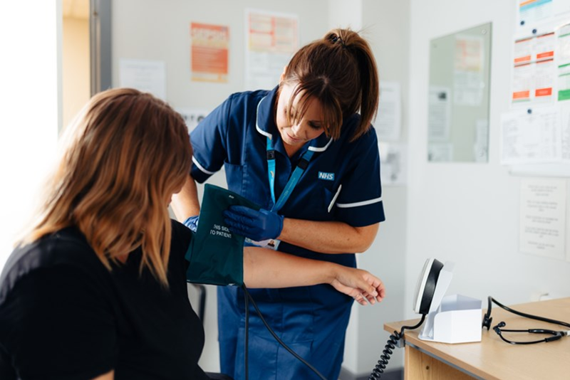 An image of a nurse treating a patient in a GP Practice