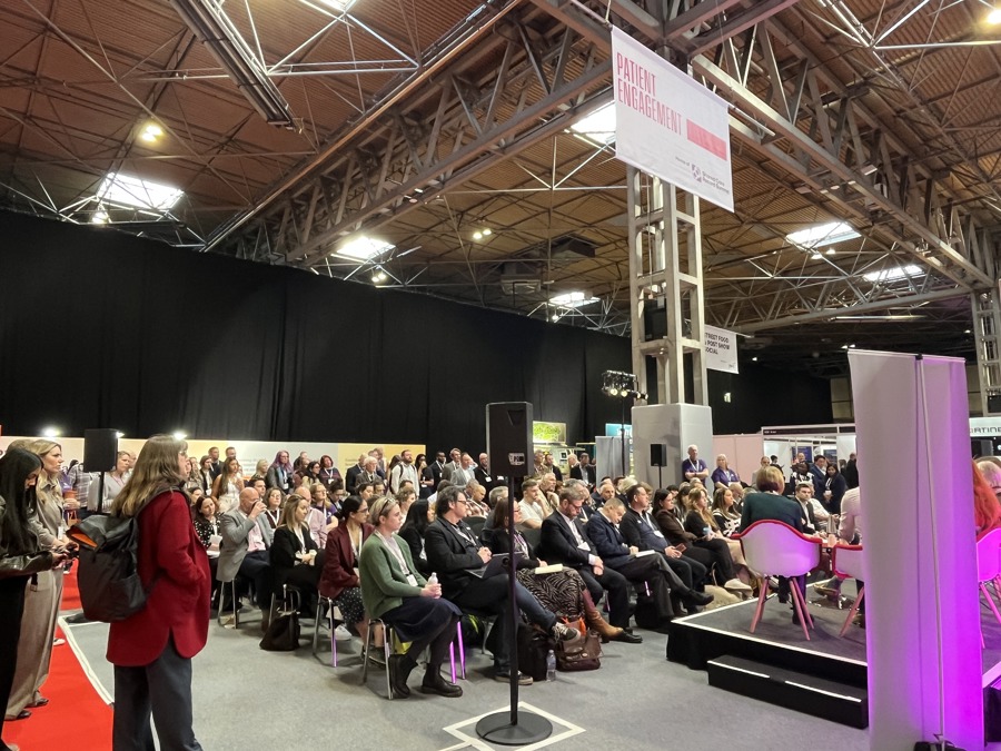 delegates in a busy conference hall seated in rows, listening to presentations at digital health rewired 2026