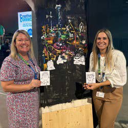 An image of two staff members holding designs on World Mental Health Day 2025